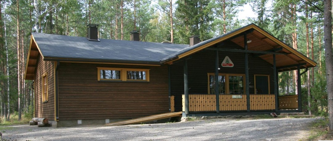 Porin Ladun toimintakeskus Susisuon maja, ruskea puurakennus, risäänkäynti kuistilta oikeasta nurkasta. On portaat ja esteetön luiska.